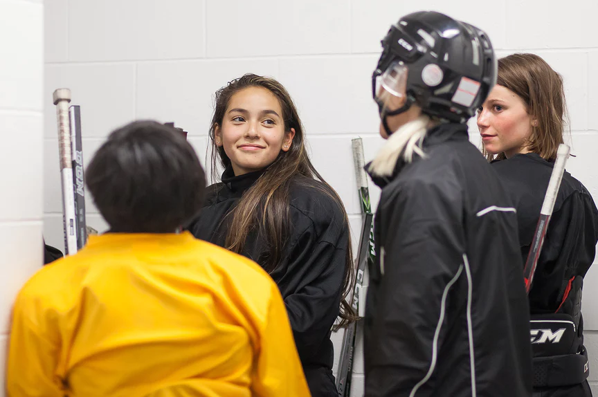 Young hockey players sharing a conversation beside the rink
